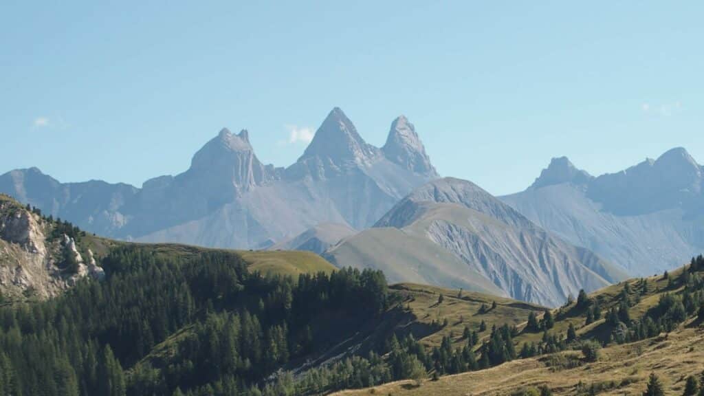 Foto genomen in liggend formaat. Op de voorgrond zien we de bergen in de zomer, met de Aiguilles d'Arves op de achtergrond.