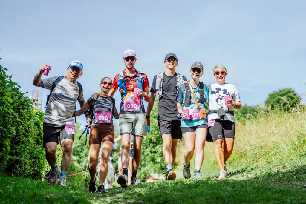 Photo paysage d'un groupe d'amis marchant sur un chemin a travers les champs. Ils sont joyeux et porte le dossard du rallye gourmand.