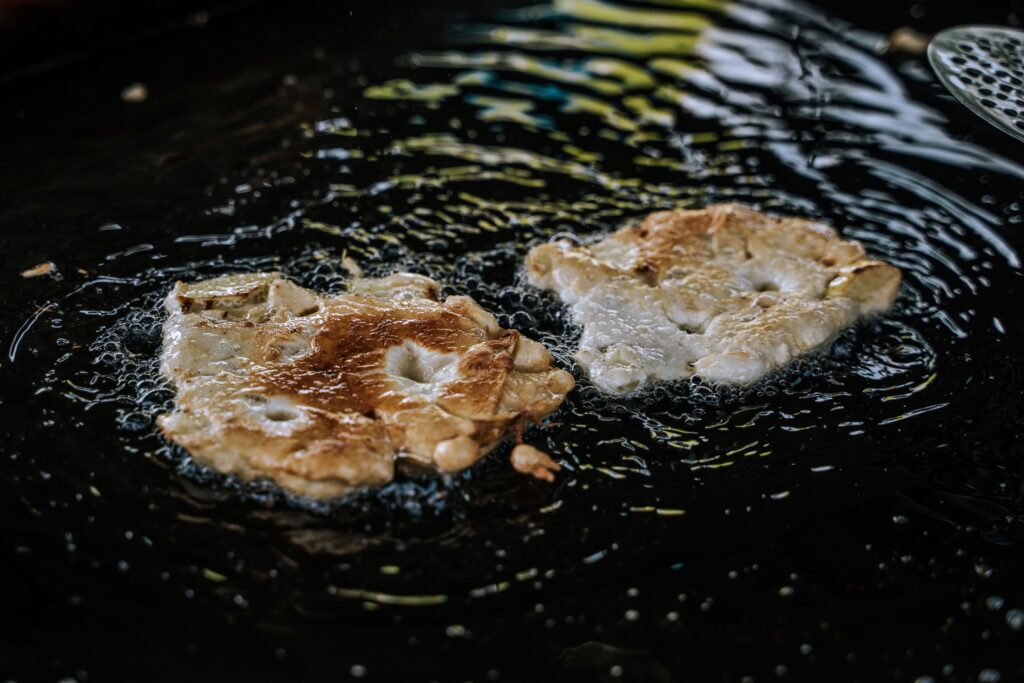 Photo en format paysage, nous pouvons voir de beignet à la pomme en train de frire. 