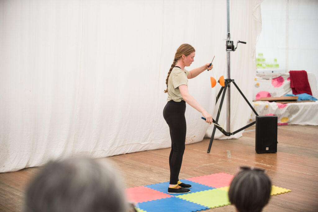 Photo prise de jour en format paysage. Nous pouvons voir une jeune fille en train de faire du diabolo.