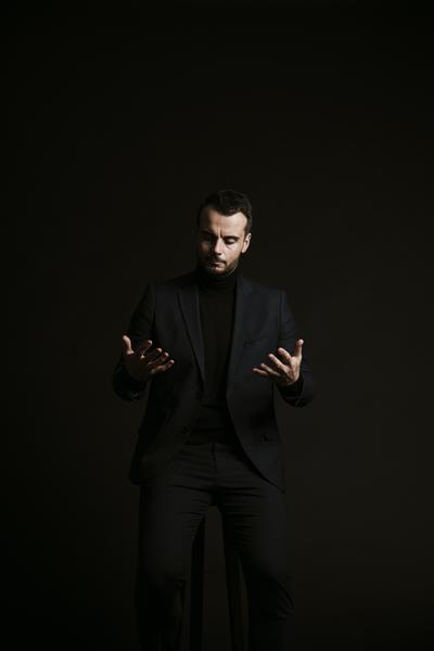 Photo de Thomas Faure, dans le noir regardant ses mains