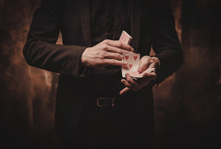 Magicien tenant dans les mains un paquet de cartes