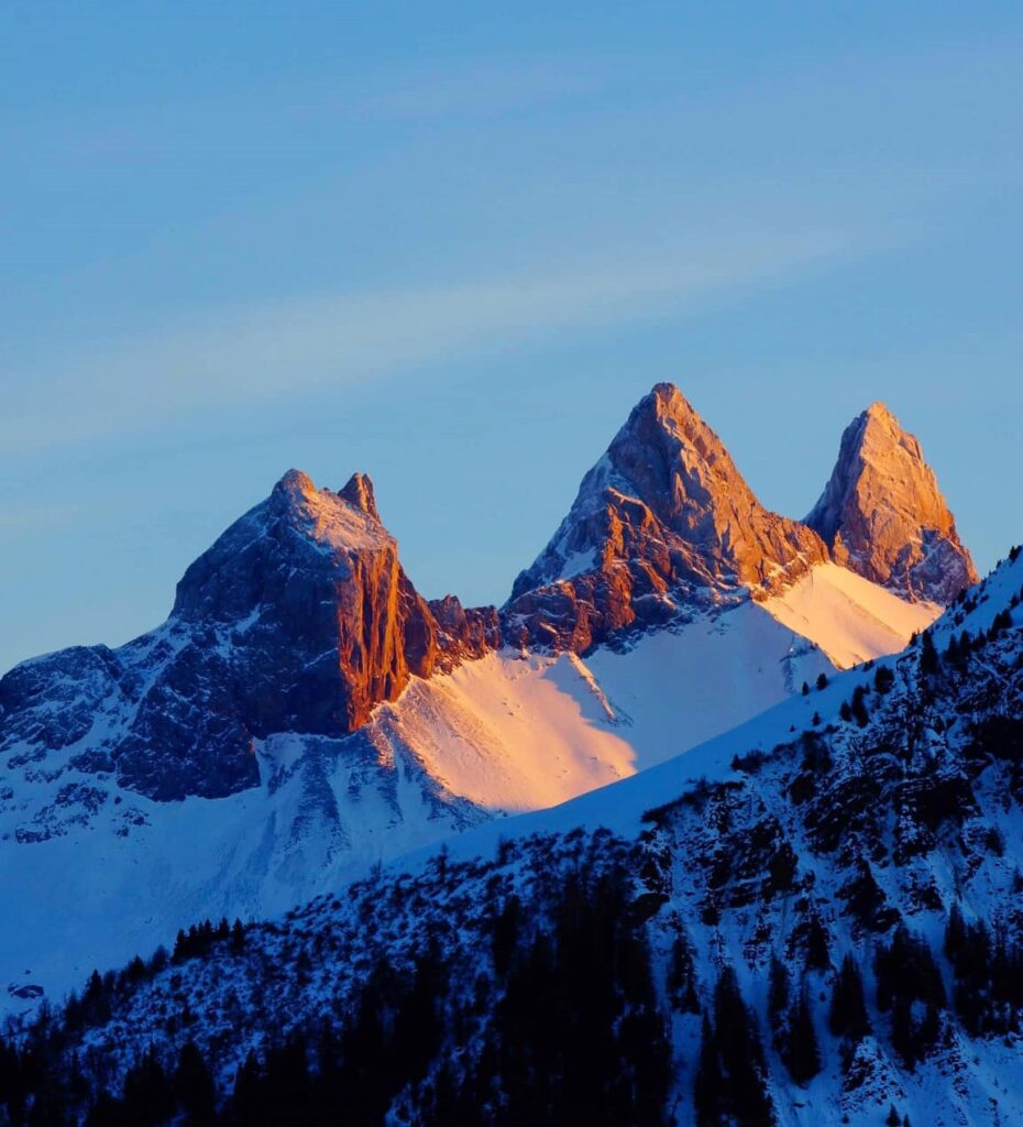 Photo prise en format portrait au couché du soleil. Nous pouvons voir les Aiguilles d'Arves enneigés avec la lueur du couché du soleil sur la roche.