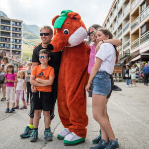 Entertainment event featuring mascot Toussy and a family in La Toussuire main street.