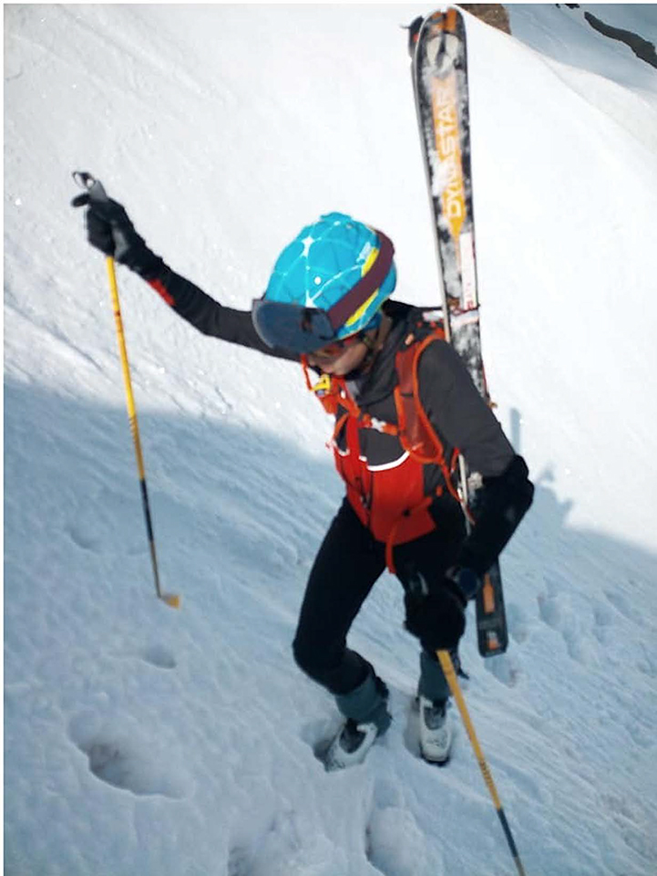 Photo prise en format vertical. Nous pouvons voir Théo en plein effort en ski alpinisme. A noter qu'il porte ses skis sur son dos