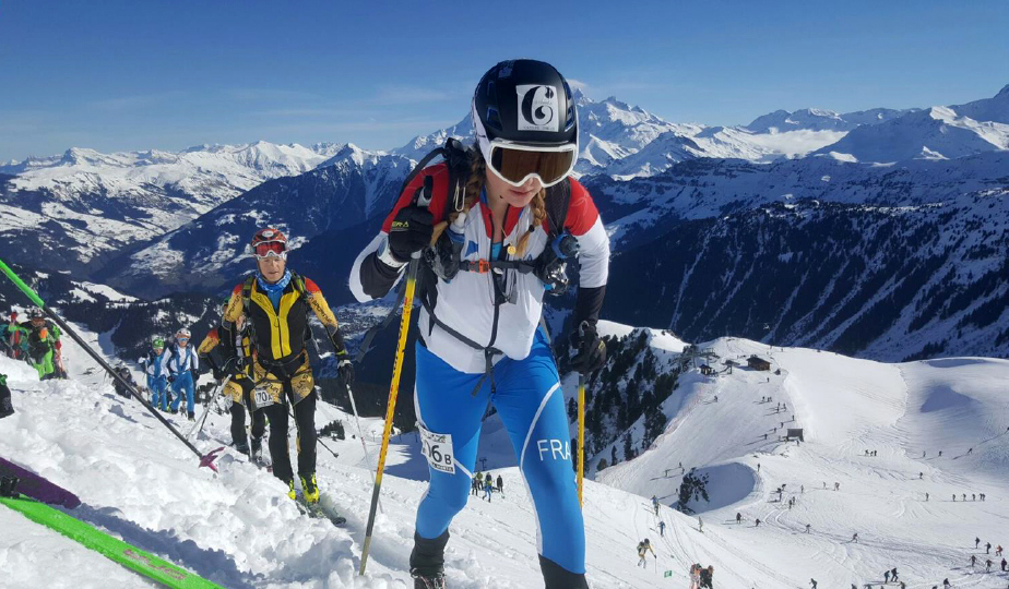 Photo en hiver lors d'une compétition de ski alpinisme : Pierra Menta. Au premier plan Candice Bonnel en pleine action avec des poursuivants derrières elle et un magnifique paysage montagneux au second plan