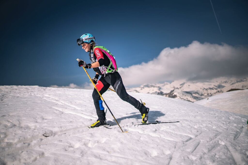 Photo prise en hiver lors d'une compétition de ski alpinisme. Nous voyons Laura Deplanche en tenue de ski alpinisme de profil en pleine action
