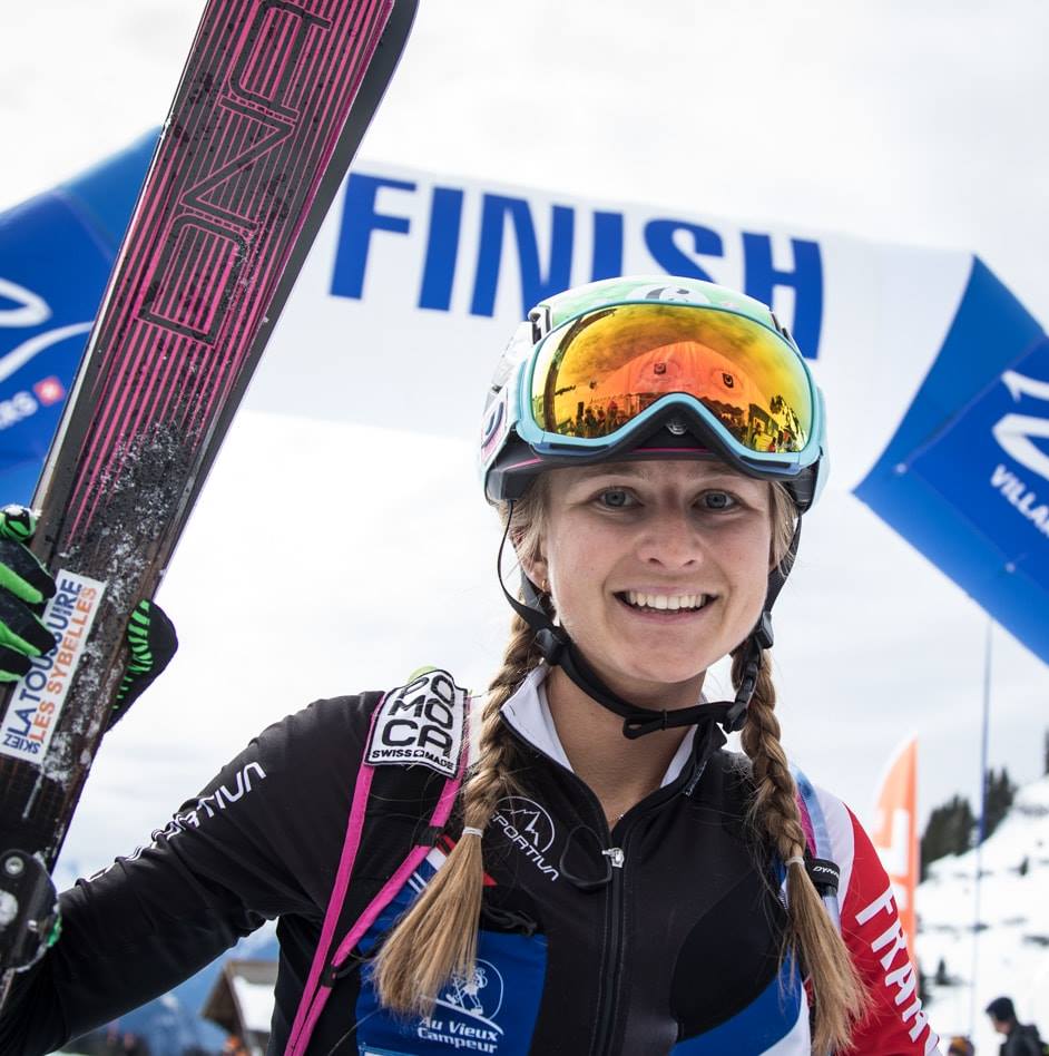 Portrait de la skieuse Léna Bonnel en tenue de ski alpinisme. Léna sourit à l'objectif après avoir franchi la ligne d'arrivée