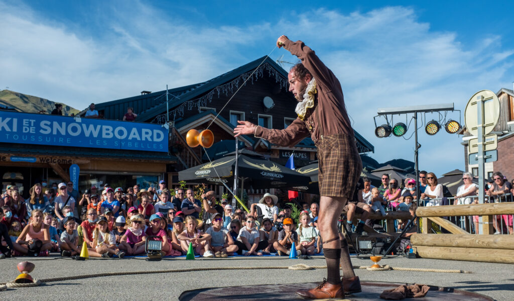 Photo prise durant l'évènement le "Festival Spectacle est dans la Rue". Au premier plan nous pouvons voir un artiste faisant du diabolo devant la foule au second plan