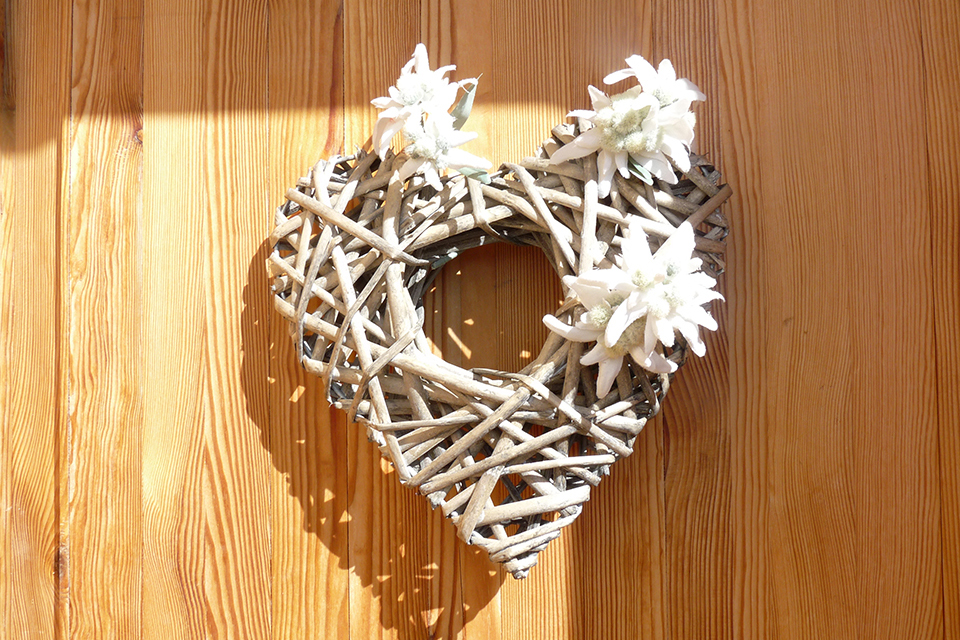 Photo d'un coeur fait de façon artisanal avec des morceaux de bois. A note qu'il y a des Edelweiss sur certains morceaux de bois