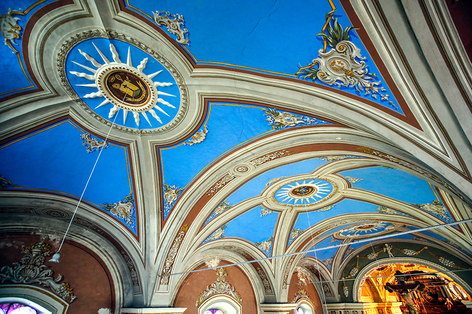 Zoom sur la plafond de l'Église de Fontcouverte. La plafond est d'un beau ciel bleu avec des moulures et des dessins dans le style baroque