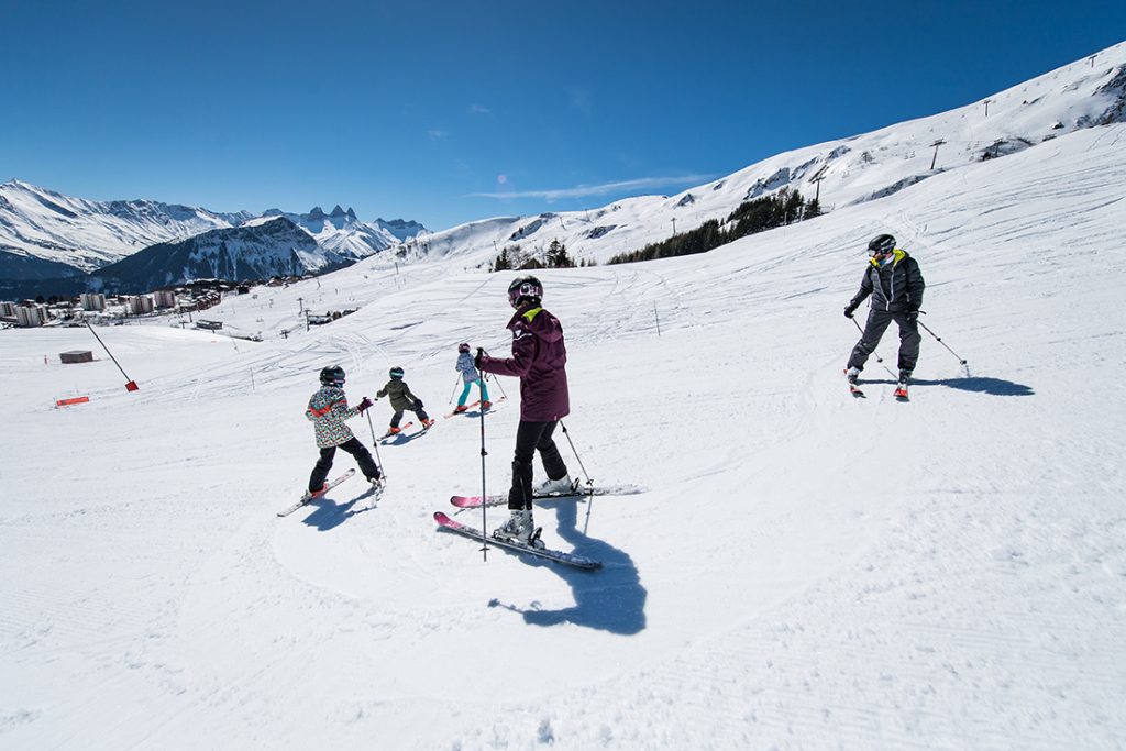 Une famille apprend à skier sur la piste des Ravières à La Toussuire