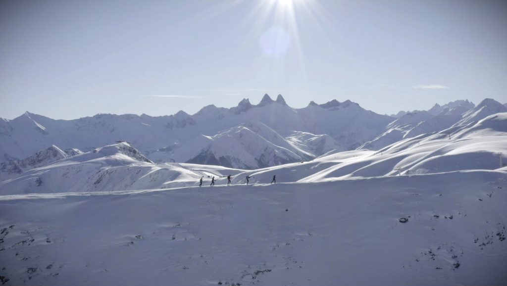 Un groupe de skieurs de randonnée sur une crête enneigée sur les hauteurs de La Toussuire vers l'Ouillon