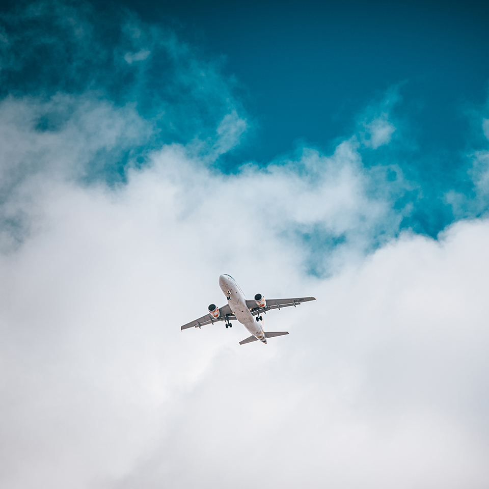 An airliner in a blue sky partially covered with white clouds