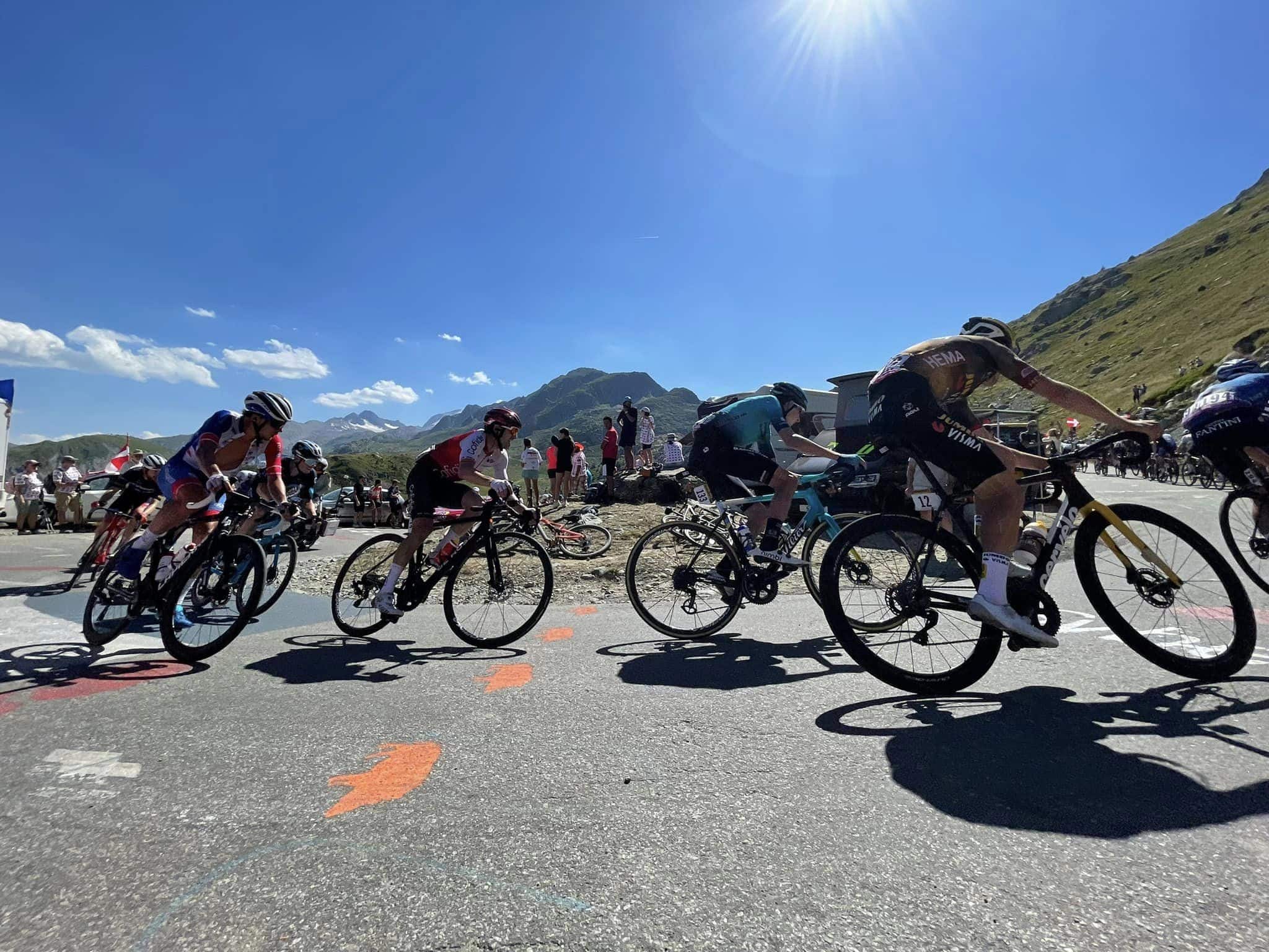Photo en format paysage, prise de jour. La photo a été prise lors de l'étape du Tour de France 2015 à La Toussuire. Nous pouvons y voir les coureurs en pleine ascension dans un virage.