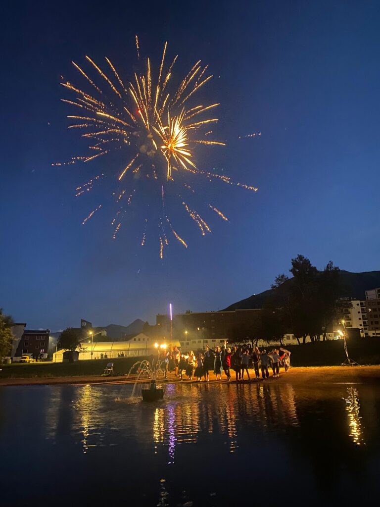 Photo du spectacle des animateurs de 2025, au plan d'eau, de nuit, avec le feu d'artifice en arrière plan